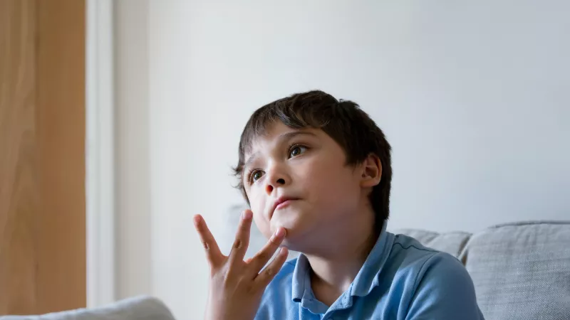 Young boy looking out deep in thought with hand o 2022 11 15 14 10 32 utc